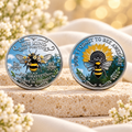 Frente e verso do modelo Abelha Bee Kind, com flores e mensagens em inglês; uma moeda por unidade.